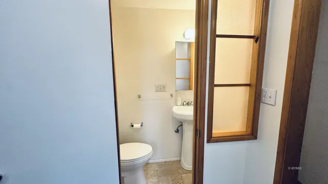 a bathroom with a granite countertop toilet and a sink