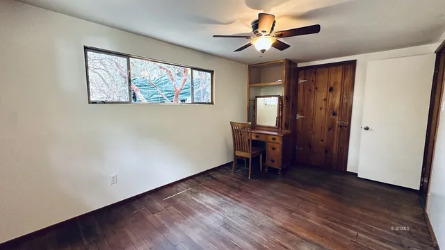 a view of a workspace with furniture and a window