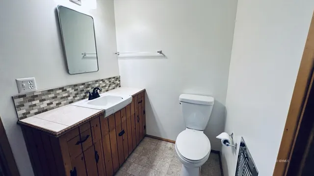 a bathroom with a toilet a sink and mirror
