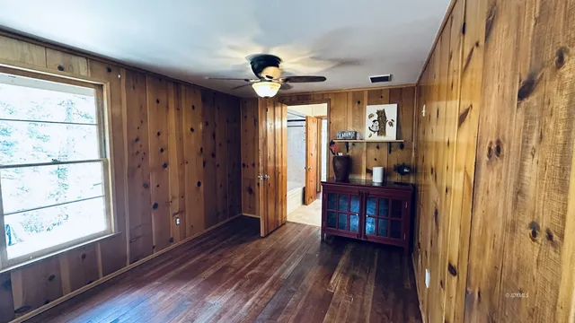 a view of a hallway with wooden floor and windows