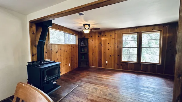 an empty room with windows and fan