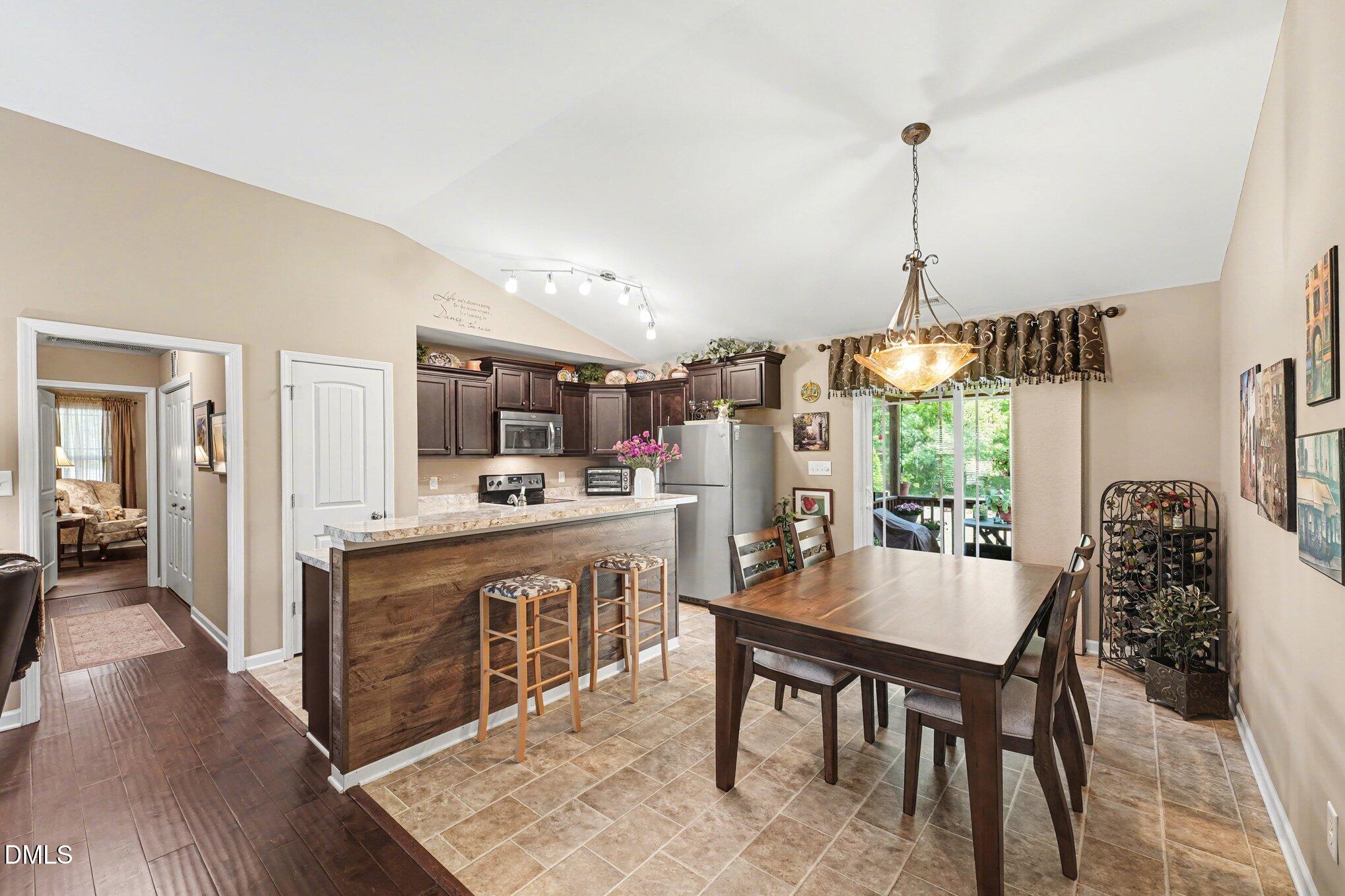 109 His Way Middlesex, NC 27557 - Photo 6 of 21 a kitchen with kitchen island a dining table chairs and white cabinets