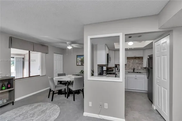 a kitchen with a dining table chairs refrigerator and cabinets