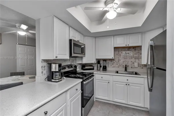 a kitchen with a sink stainless steel appliances and white cabinets