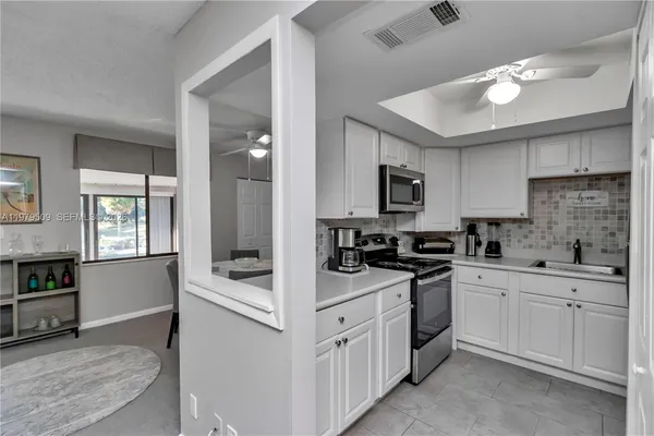 a kitchen with white cabinets and white appliances