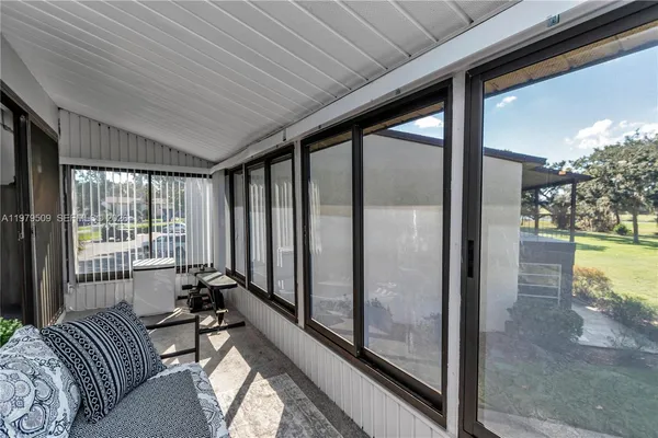 a living room with a bed and glass windows