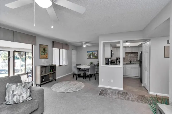 a living room with furniture and a dining table with kitchen view