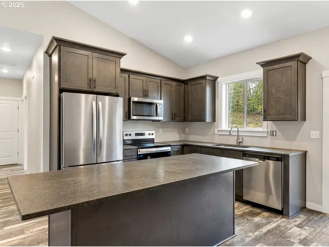 a kitchen with stainless steel appliances a refrigerator sink and microwave