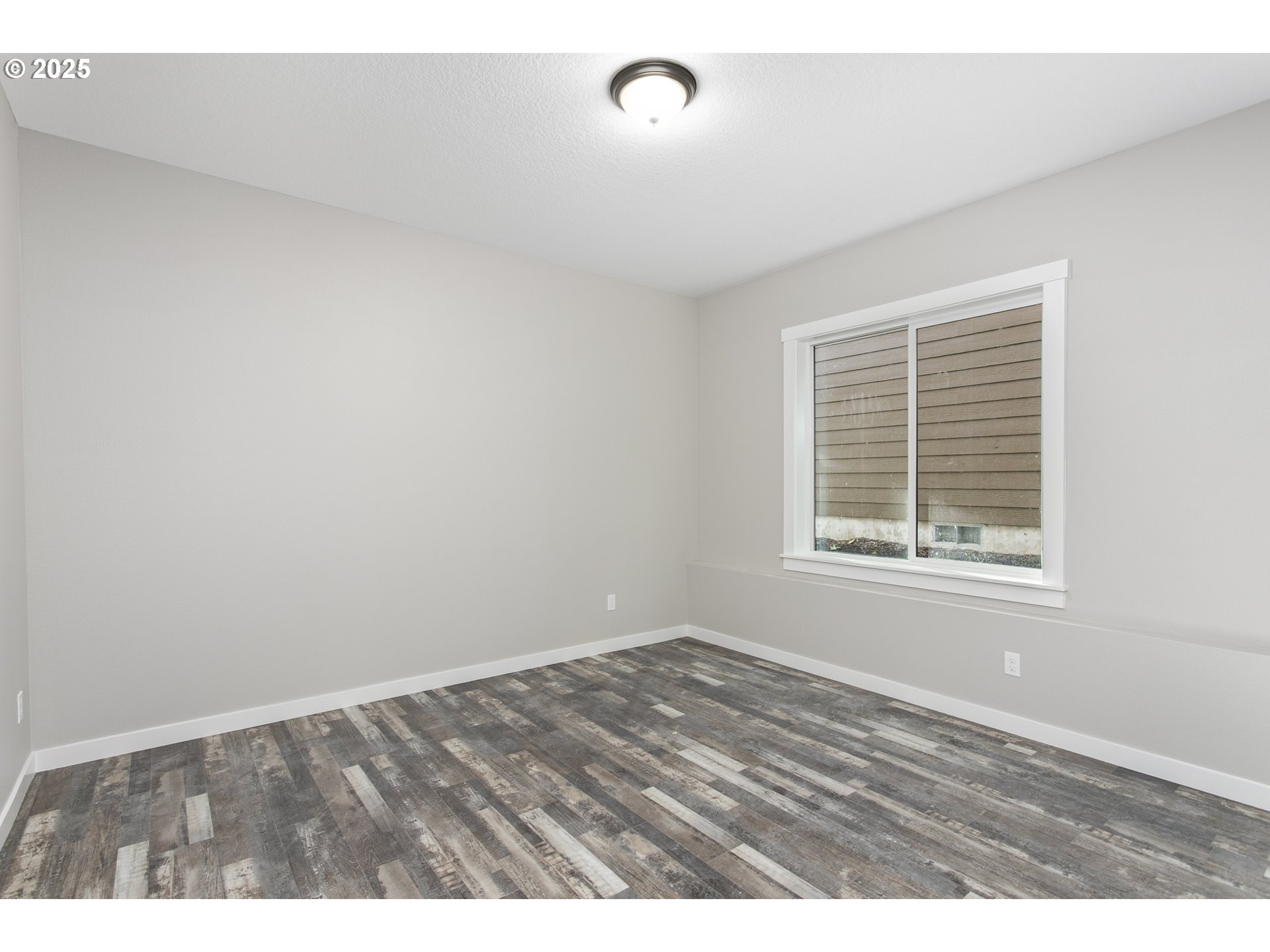 158 East H Street Vernonia, OR 97064 - Photo 21 of 33 a view of an empty room with wooden floor and a window