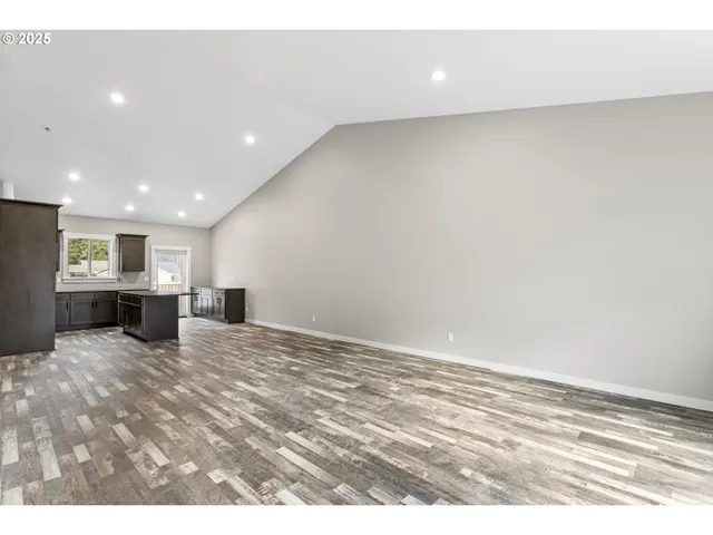 a view of an empty room with a kitchen