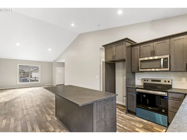 a kitchen with stainless steel appliances a stove cabinets and wooden floor
