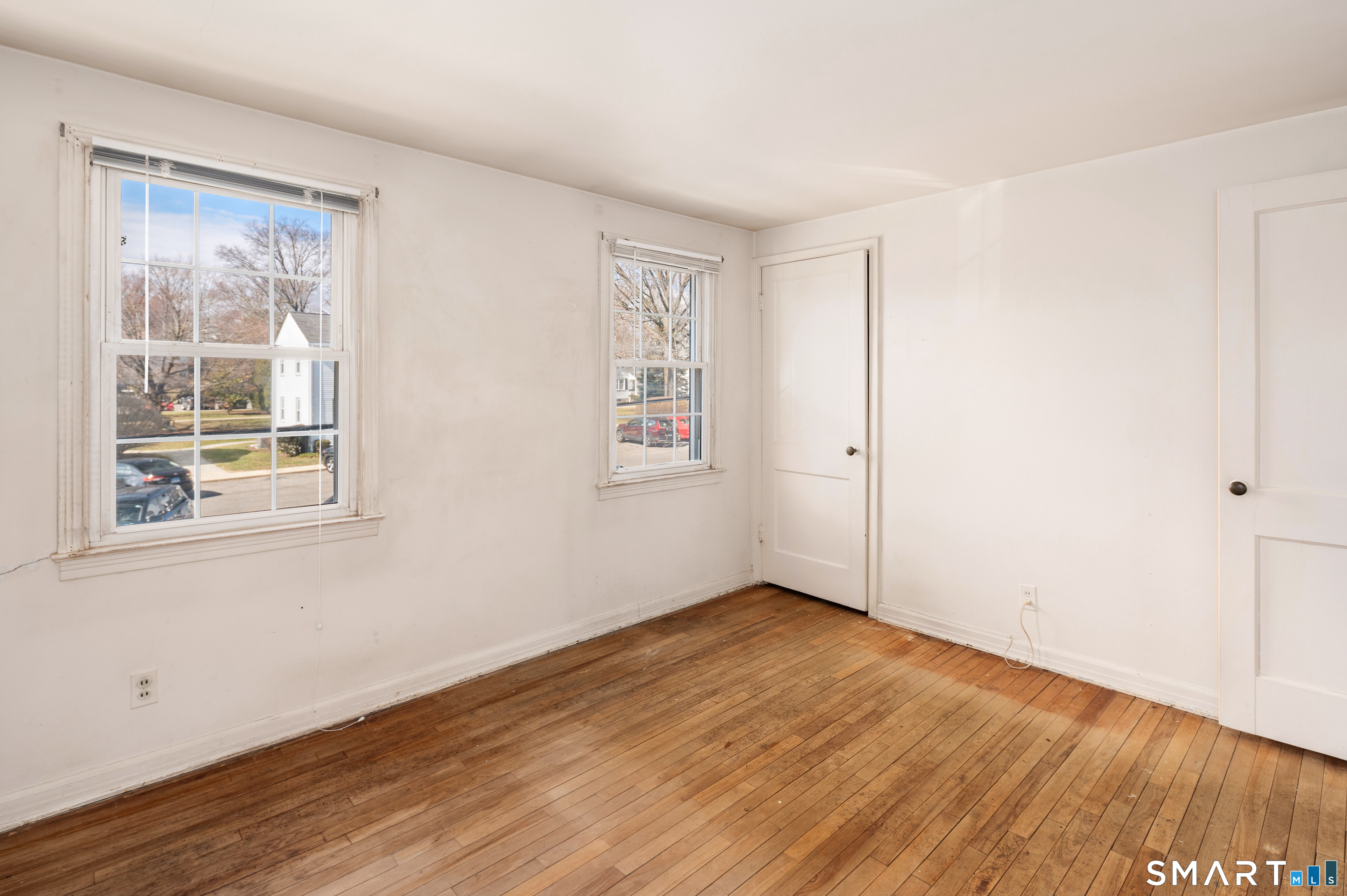 221 Sylvan Knoll Road Stamford, CT 06902 - Photo 16 of 22 an empty room with wooden floor and windows