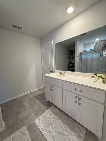 a spacious bathroom with a double vanity sink and mirror