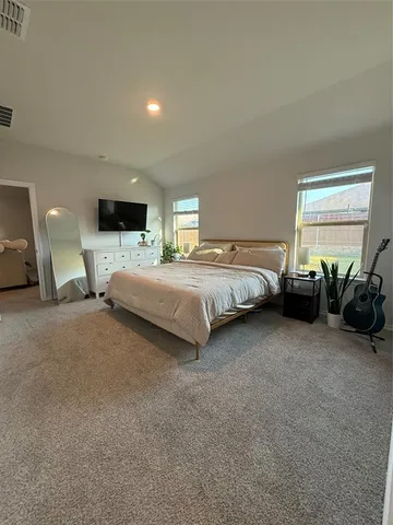 a spacious bedroom with a bed a mirror and a flat screen television
