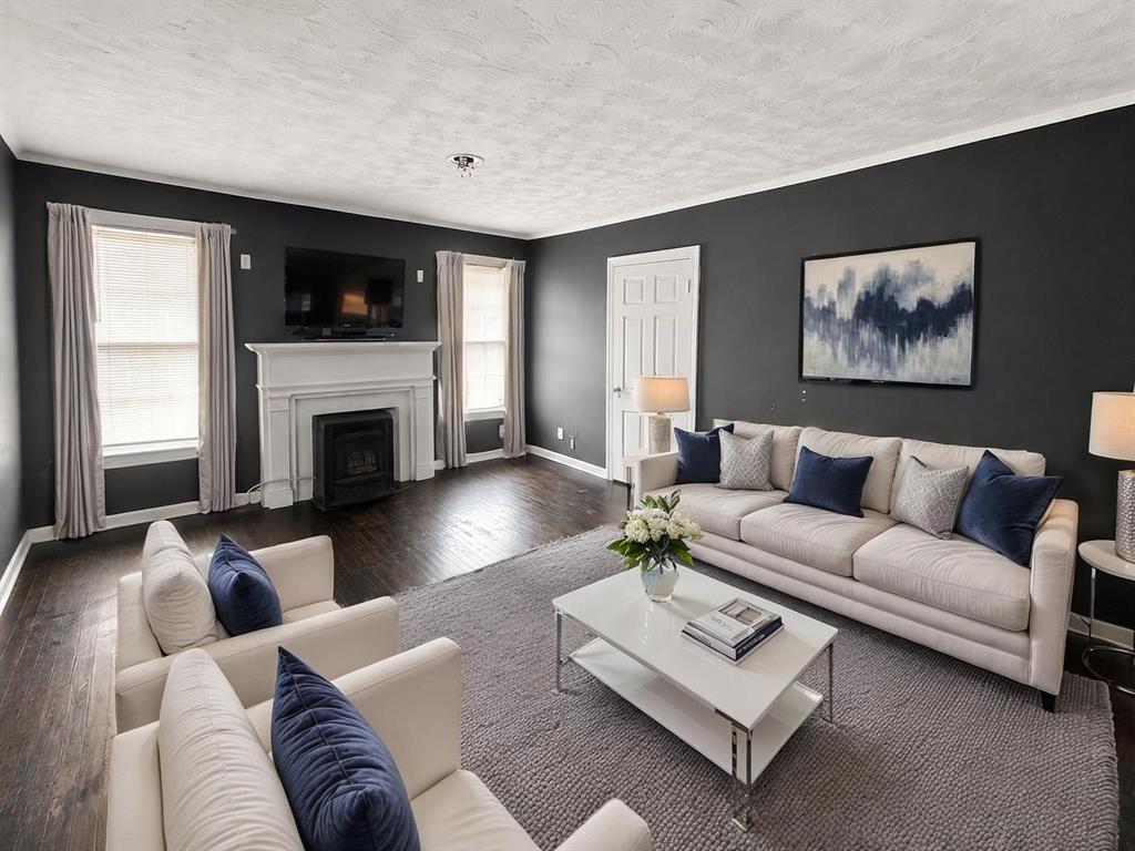 1010 Winters Street Dallas, TX 75216 - Photo 2 of 20 Living area featuring dark wood-finish flooring, a white mantel fireplace, and crown molding