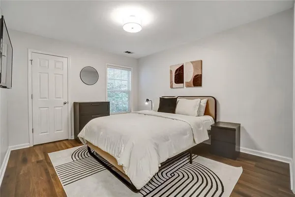 a bedroom with a bed and wooden floor