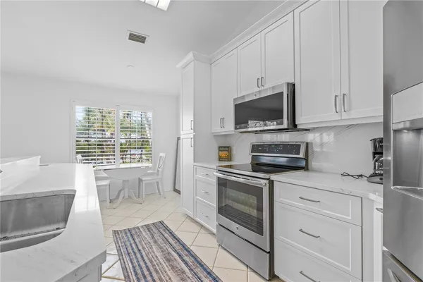 a kitchen with granite countertop a stove a sink and a microwave