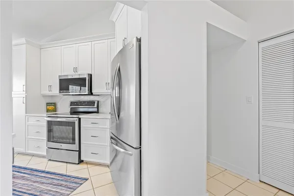 a kitchen with stainless steel appliances granite countertop a refrigerator and a stove top oven