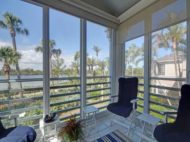 a living room with couches and a floor to ceiling window