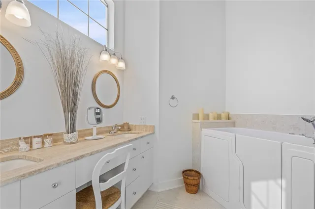 a bathroom with a sink and mirror with bathtub