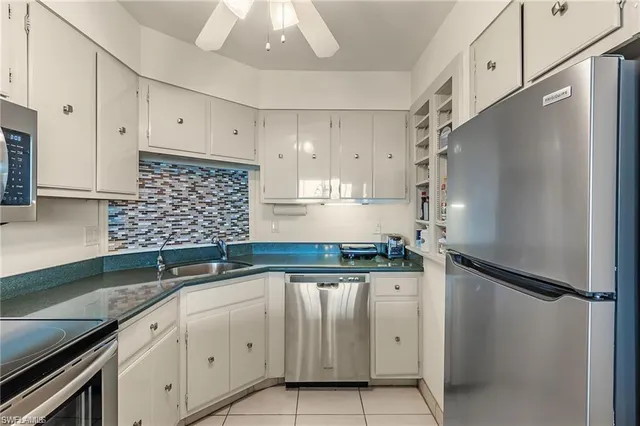 a kitchen with granite countertop a sink stainless steel appliances and cabinets