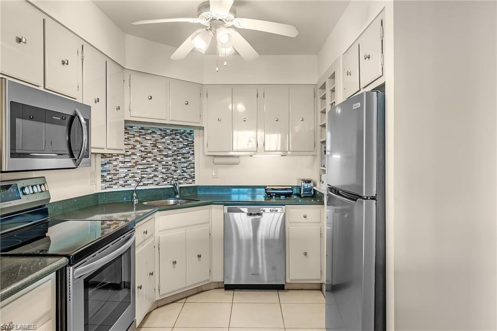 5 Bluebill Avenue, Unit 403 Naples, FL 34108 - Photo 11 of 41 a kitchen with a sink cabinets and appliances