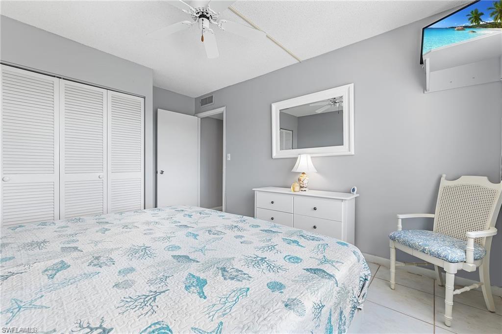 5 Bluebill Avenue, Unit 403 Naples, FL 34108 - Photo 23 of 41 a bedroom with a bed and a chair