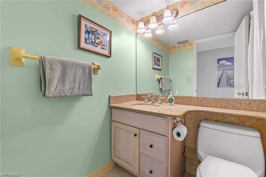 5 Bluebill Avenue, Unit 403 Naples, FL 34108 - Photo 24 of 41 a bathroom with a toilet a sink and mirror