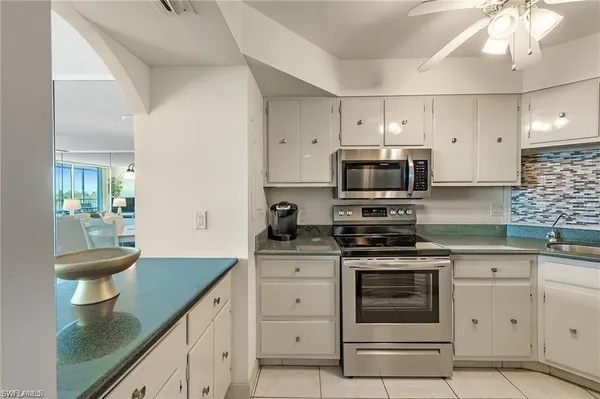 a kitchen with white cabinets appliances and a sink