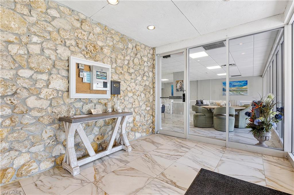 5 Bluebill Avenue, Unit 403 Naples, FL 34108 - Photo 39 of 41 a spacious bathroom with a granite countertop sink a mirror and a shower