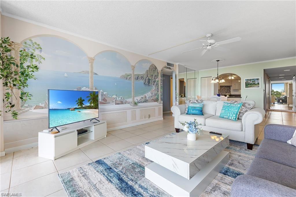 5 Bluebill Avenue, Unit 403 Naples, FL 34108 - Photo 4 of 41 a living room with furniture a chandelier and a table