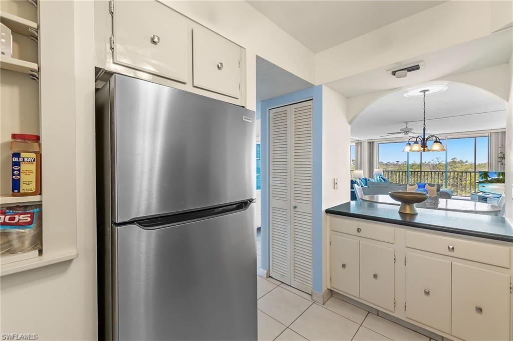 5 Bluebill Avenue, Unit 403 Naples, FL 34108 - Photo 9 of 41 a kitchen with appliances a sink and cabinets