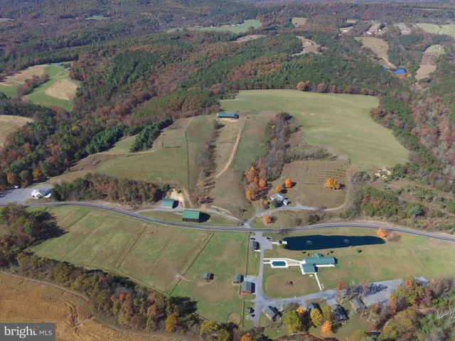 an aerial view of a house with a yard and lake view