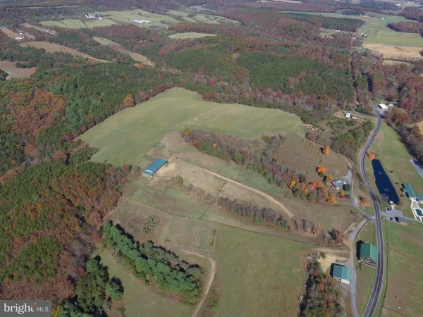 an aerial view of a house with outdoor space and a lake view in back
