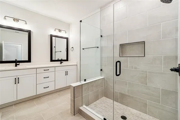 a bathroom with a double vanity sink and mirror