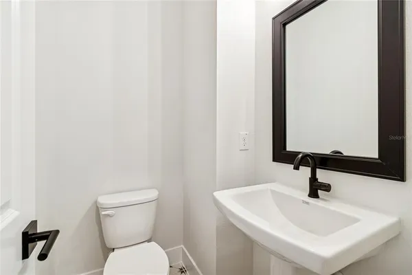 a bathroom with a sink a toilet and mirror