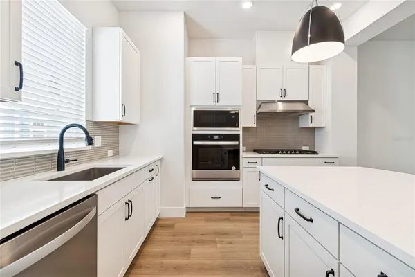 a kitchen with a sink a stove and cabinets