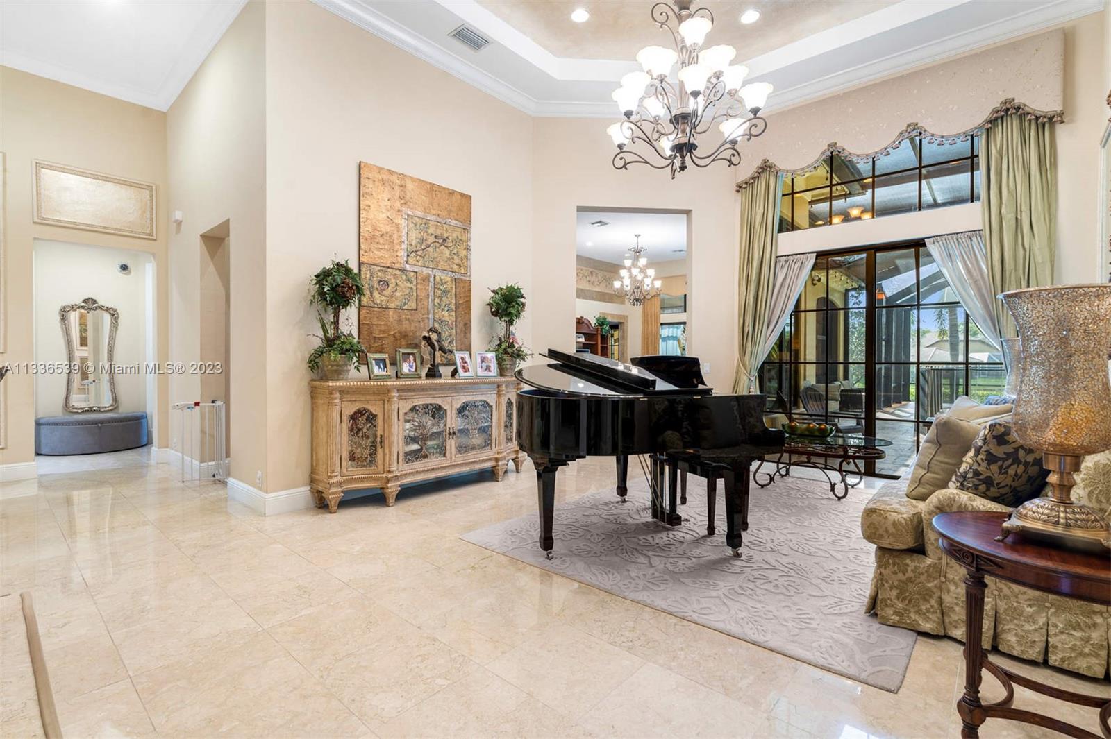 6911 Long Leaf Drive Parkland, FL 33076 - Photo 2 of 20 a living room with furniture a chandelier and a flat screen tv