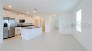 11142 Radiant Shr Loop San Antonio, FL 33576 - Photo 11 of 43 a kitchen with stainless steel appliances a refrigerator a stove a microwave and a refrigerator