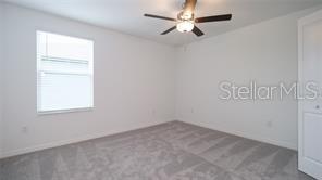 11142 Radiant Shr Loop San Antonio, FL 33576 - Photo 18 of 43 an empty room with a window and a fan