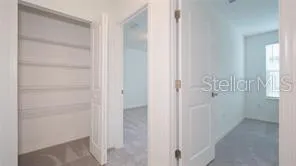 an empty room with closet and a chandelier fan