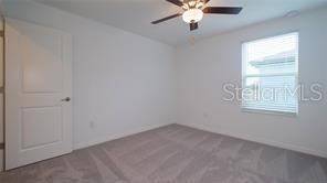 11142 Radiant Shr Loop San Antonio, FL 33576 - Photo 22 of 43 an empty room with windows and fan