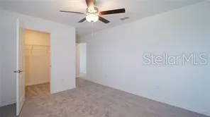 an empty room with a ceiling fan and window