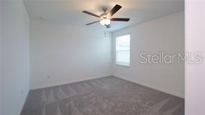 11142 Radiant Shr Loop San Antonio, FL 33576 - Photo 28 of 43 an empty room with a ceiling fan and window