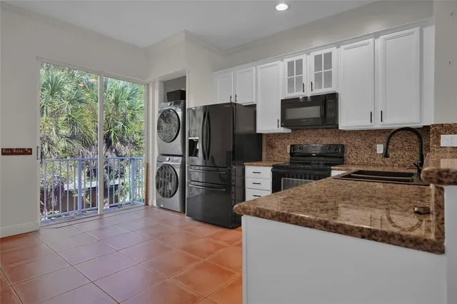 a kitchen with stainless steel appliances granite countertop a refrigerator stove and sink