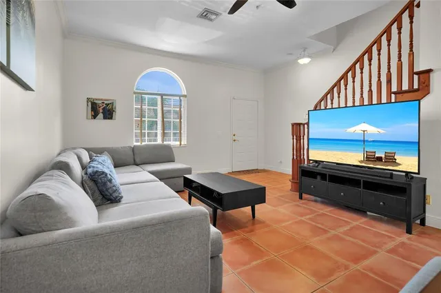 a living room with furniture a flat screen tv and a window