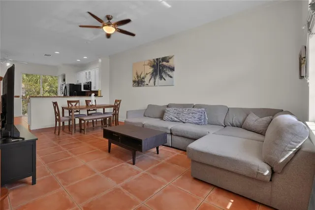 a living room with furniture a dining table and a chandelier