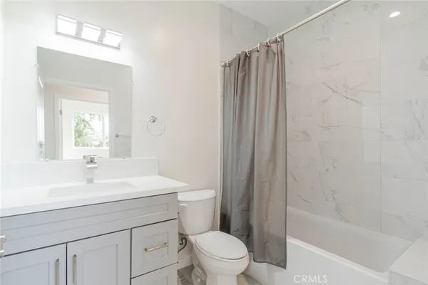 a bathroom with a sink a toilet a mirror and shower