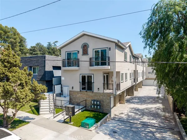 a white house that has tree in front of it