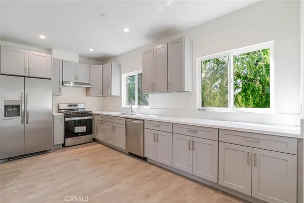 a kitchen with granite countertop white cabinets and stainless steel appliances